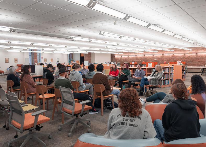 Students and guests listen to faculty speaking panel in library